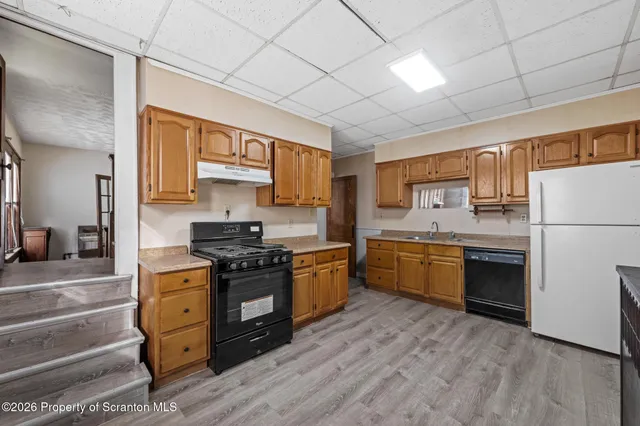 a kitchen with stainless steel appliances granite countertop a stove a sink dishwasher and a refrigerator
