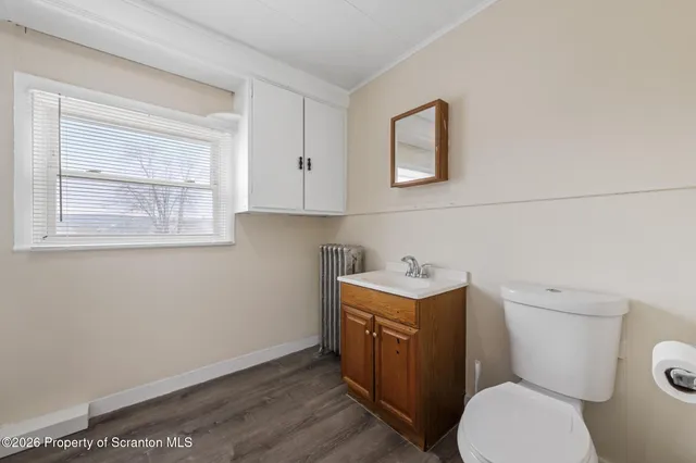 a bathroom with a toilet a sink a vanity and mirror