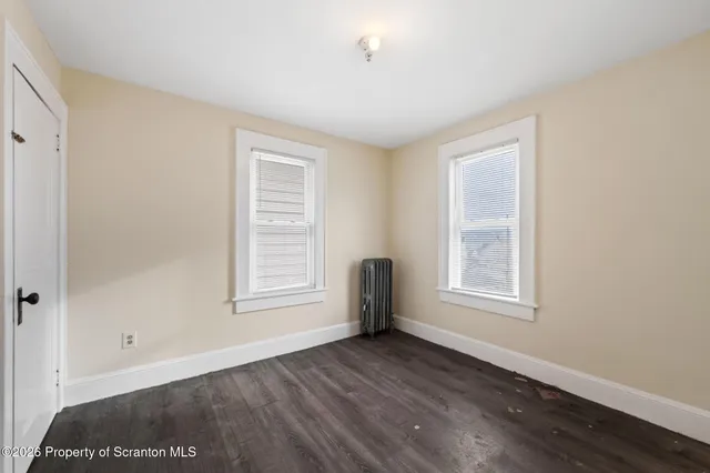 a view of an empty room with wooden floor