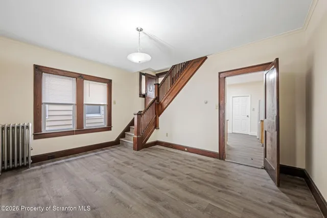 a view of an empty room with glass door and stairs
