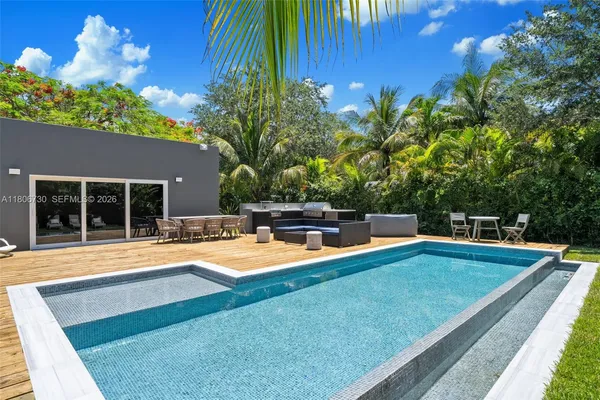 a view of a house with backyard and sitting area