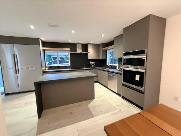 a bedroom with a large bed and a flat tv screen on dresser