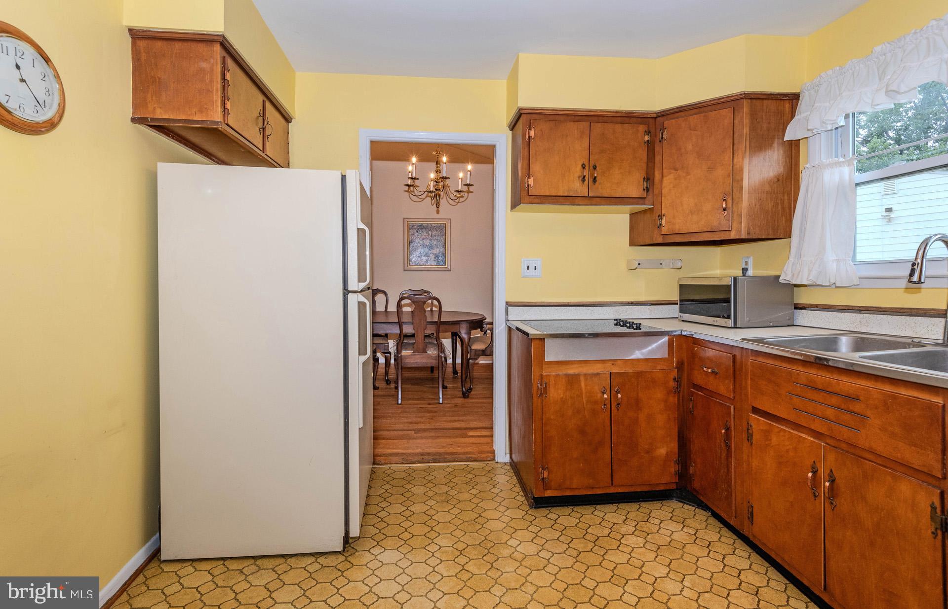 208 Ardmore Road Linthicum Heights, MD 21090 - Photo 16 of 58 a kitchen with stainless steel appliances granite countertop a refrigerator a sink a stove and wooden cabinets