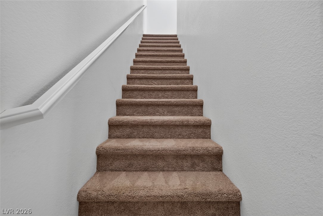 1100 East Sunset Road Henderson, NV 89011 - Photo 29 of 58 Carpeted stairs invite residents to the upper floor, with a clean white handrail providing support.
