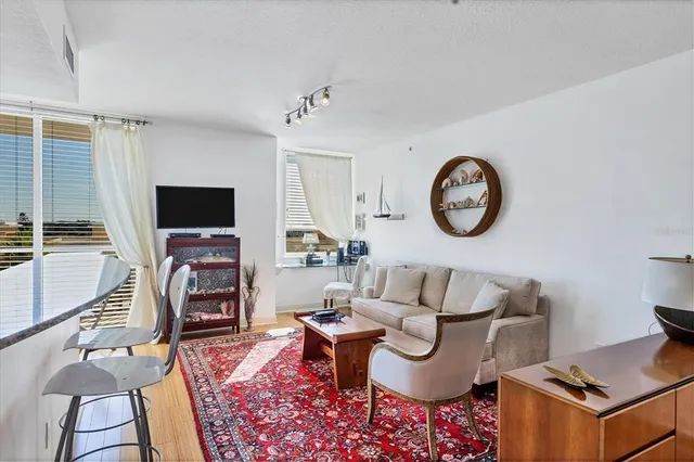 a living room with furniture a clock on wall and a table