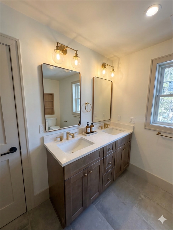 104 Page Road Bedford, MA 01730 - Photo 12 of 24 a bathroom with a double vanity sink and mirror