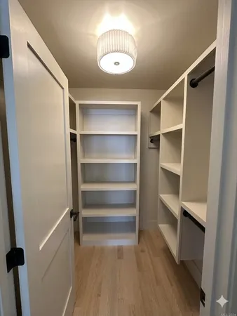 a view of walk in closet with empty racks