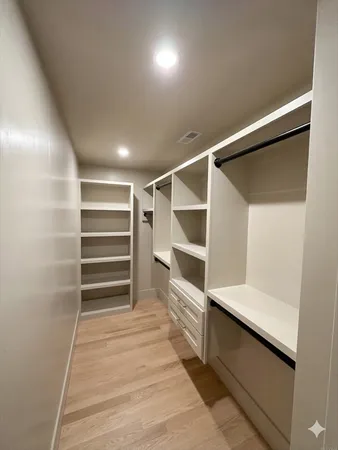 a view of walk in closet with empty racks