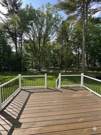 a view of a balcony with wooden floor and fence