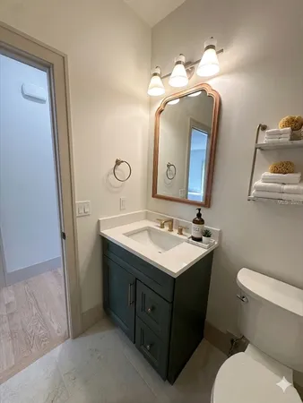 a bathroom with a toilet sink and mirror
