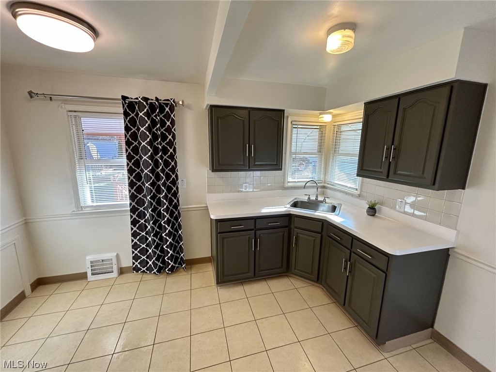 13414 Rockside Road Garfield Heights, OH 44125 - Photo 7 of 25 Kitchen featuring sink, plenty of natural light, tasteful backsplash, and light tile floors