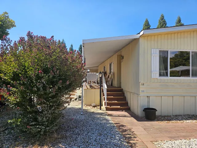 a view of a house with backyard and wooden fence