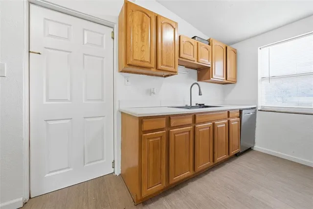 a kitchen with stainless steel appliances granite countertop a sink and dishwasher with wooden cabinets