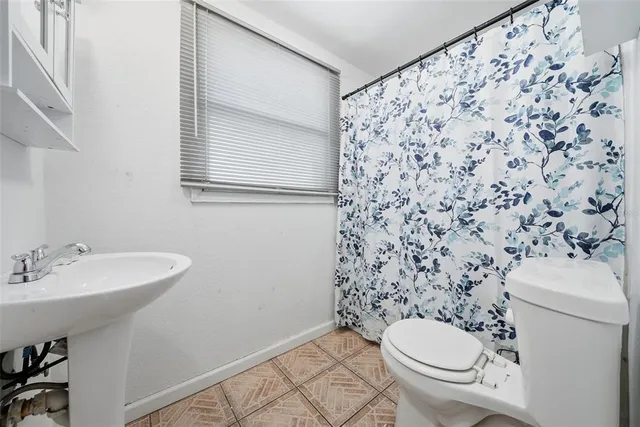 a bathroom with a sink toilet and a mirror