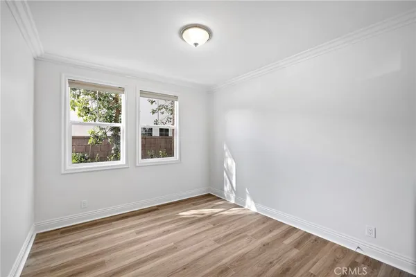 a view of a hallway with wooden floor and windows