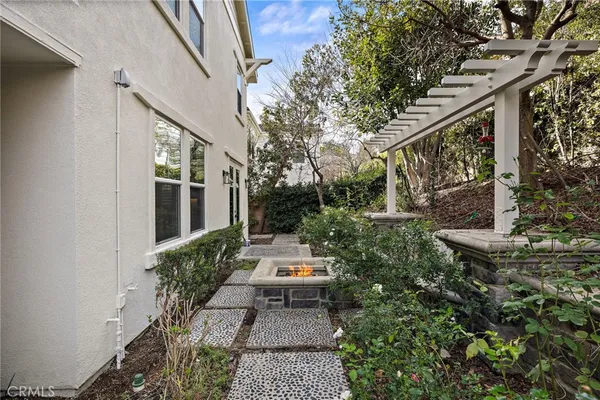 a white house with a large yard and large trees