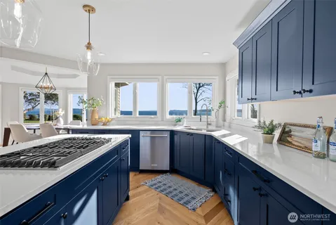 a kitchen with granite countertop stainless steel appliances a sink stove and cabinets