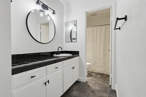 a bathroom with a granite countertop sink and a mirror