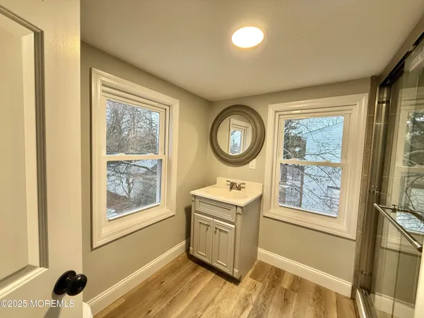 a room with stainless steel appliances wooden floor and window