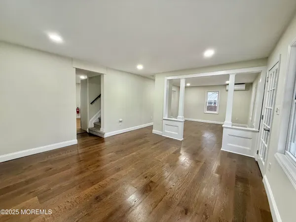 a view of empty room with wooden floor