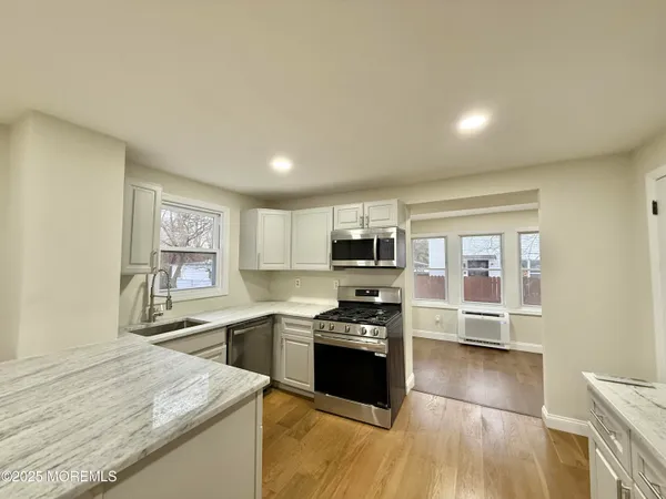 a kitchen with stainless steel appliances kitchen island granite countertop a stove a sink and a microwave