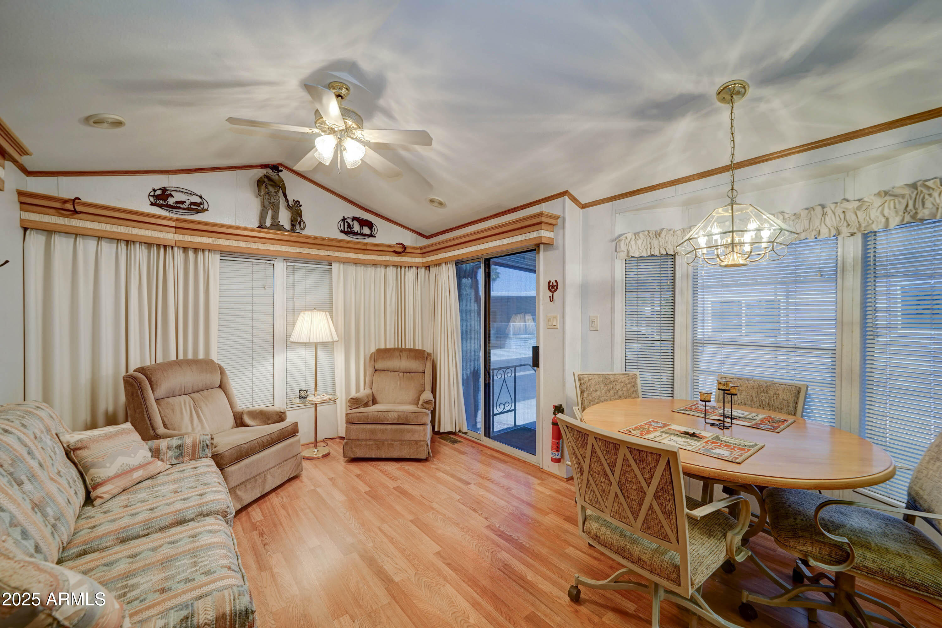 111 South Greenfield Road, Unit 405 Mesa, AZ 85206 - Photo 3 of 22 a living room with furniture a chandelier and a wooden floor