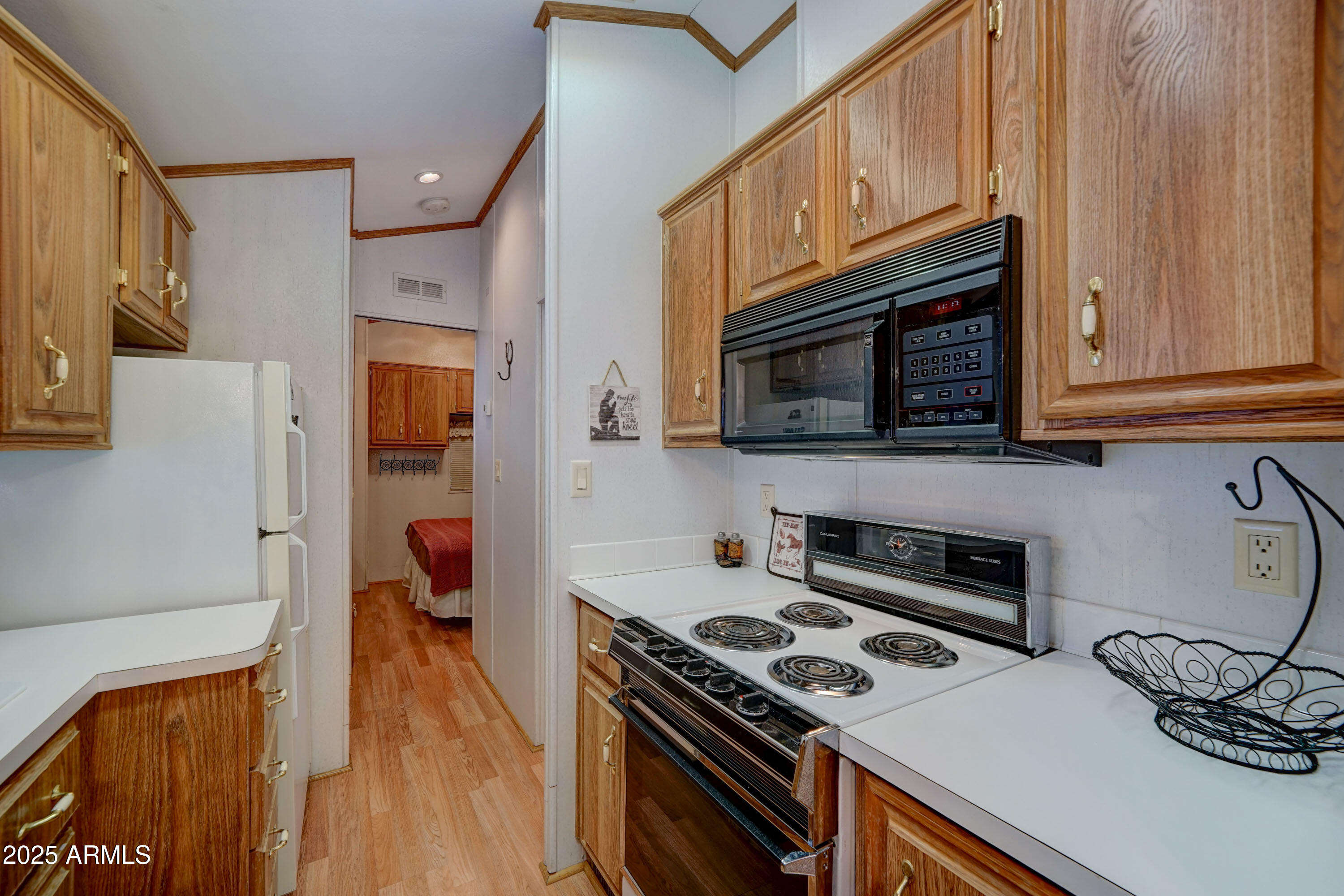 111 South Greenfield Road, Unit 405 Mesa, AZ 85206 - Photo 4 of 22 a kitchen with stainless steel appliances a stove a microwave and wooden cabinets