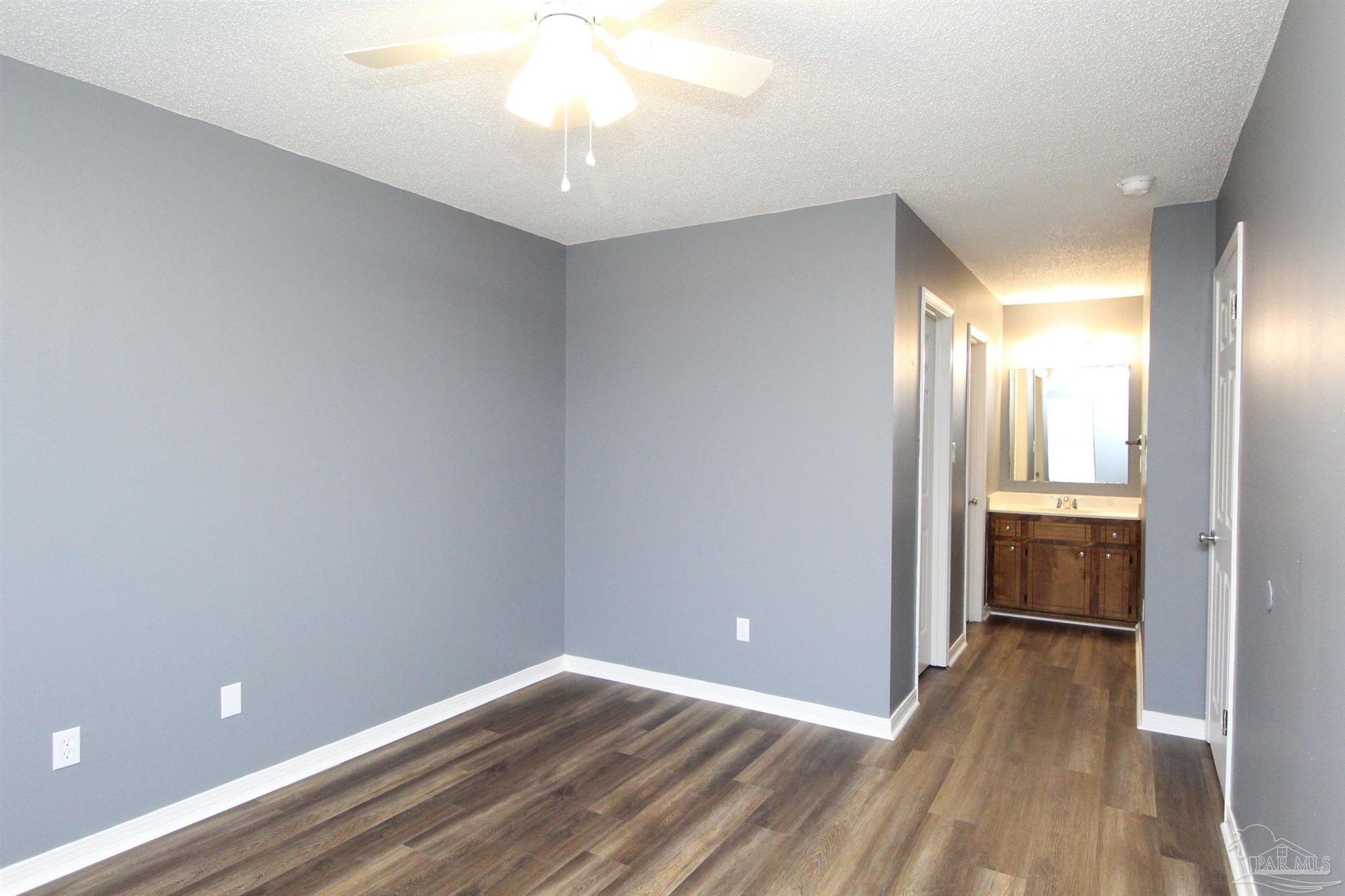2995 Junction Drive, Unit C4 Cantonment, FL 32533 - Photo 11 of 14 a view of a room with wooden floor and a ceiling fan