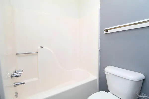 a white toilet sitting next to a bath tub