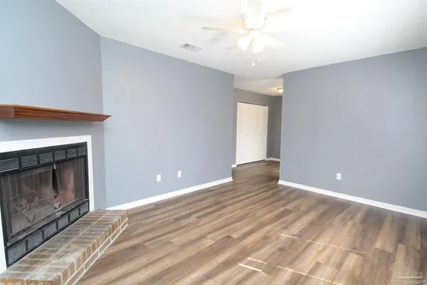 a view of an empty room with window and fire place