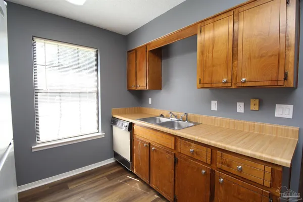 a kitchen with stainless steel appliances granite countertop wooden cabinets a sink and a window
