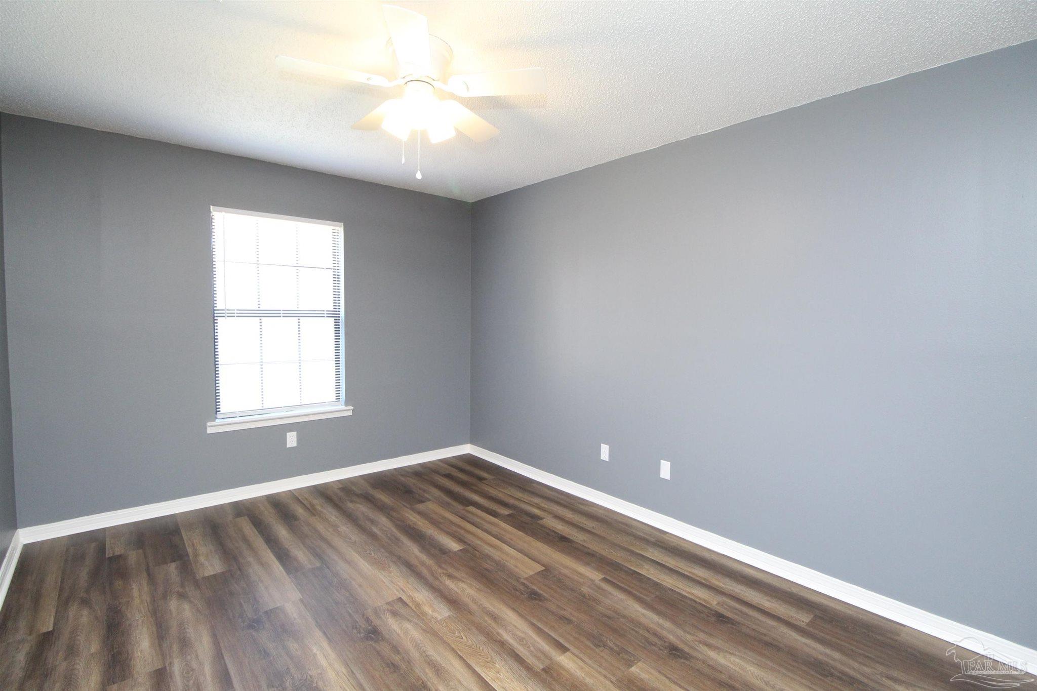2995 Junction Drive, Unit C4 Cantonment, FL 32533 - Photo 10 of 14 wooden floor in an empty room with a window