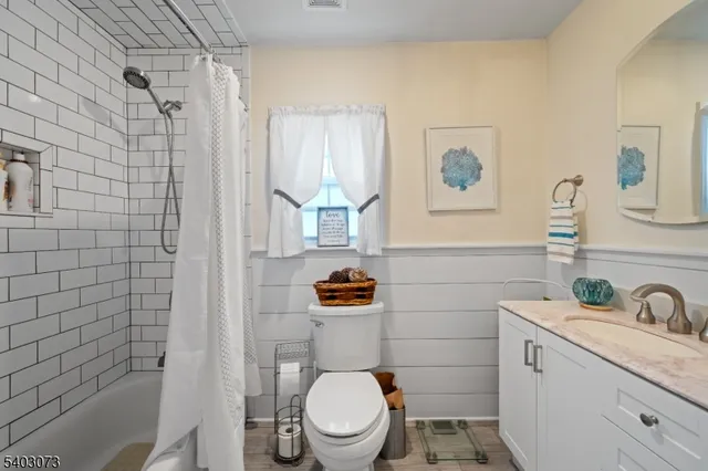 a bathroom with a granite countertop toilet a sink and a shower
