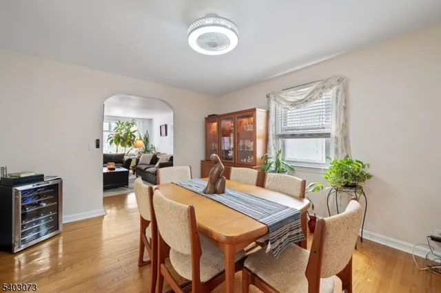 a dining room with furniture potted plants and wooden floor