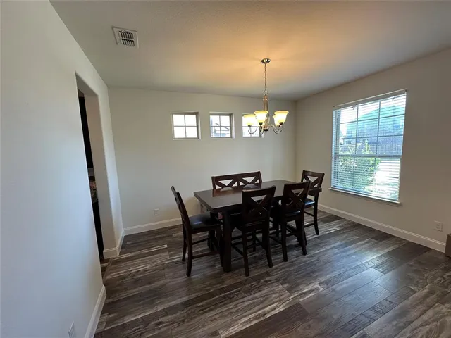 a view of a dining room with furniture and chandelier