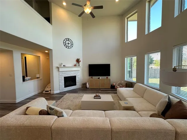 a living room with furniture a flat screen tv and a fireplace