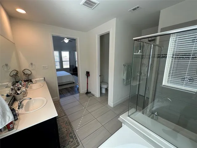 a bedroom with a bed wooden floor and a large window