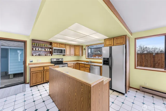 a kitchen with a sink a refrigerator and cabinets