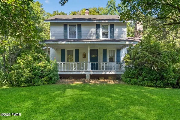 a view of house with a yard and sitting area