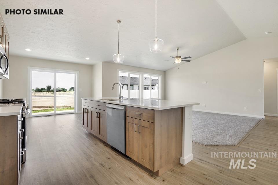 1652 Haystack Road Emmett, ID 83617 - Photo 9 of 29 Modern kitchen featuring a central island with a sink, stainless steel dishwasher, and pendant lighting