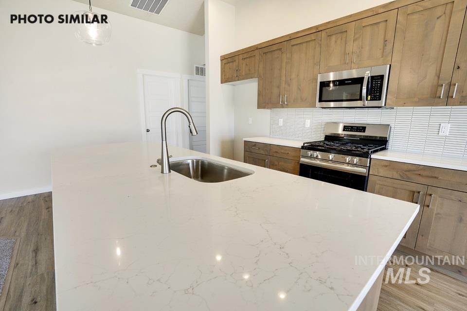 1652 Haystack Road Emmett, ID 83617 - Photo 11 of 29 Kitchen island with a stainless steel undermount sink and a gooseneck faucet