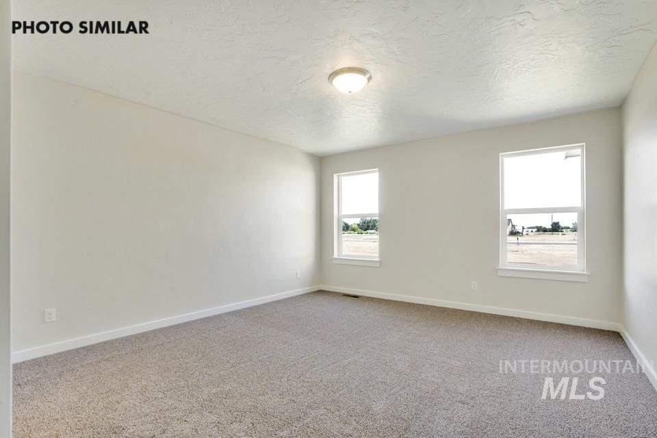 1652 Haystack Road Emmett, ID 83617 - Photo 14 of 29 Carpeted room featuring two windows with white trim and a flush-mount ceiling light fixture