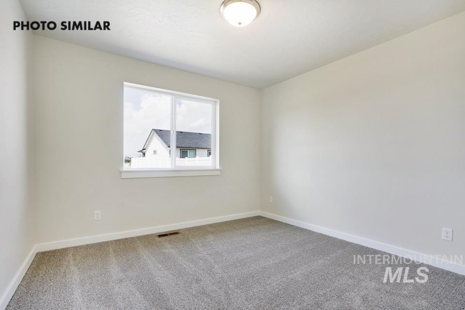 1652 Haystack Road Emmett, ID 83617 - Photo 27 of 29 Light-filled room featuring neutral wall paint, gray carpet flooring, a large window, and white trim