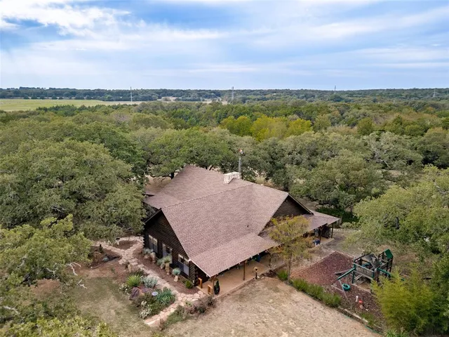 an aerial view of a house with a yard and lake view