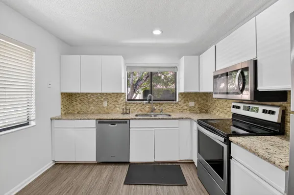 a kitchen with stainless steel appliances granite countertop a stove and a sink