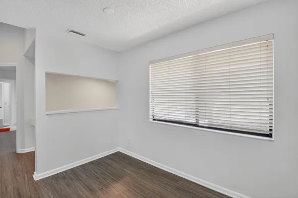 a view of a small space with wooden floor and a window