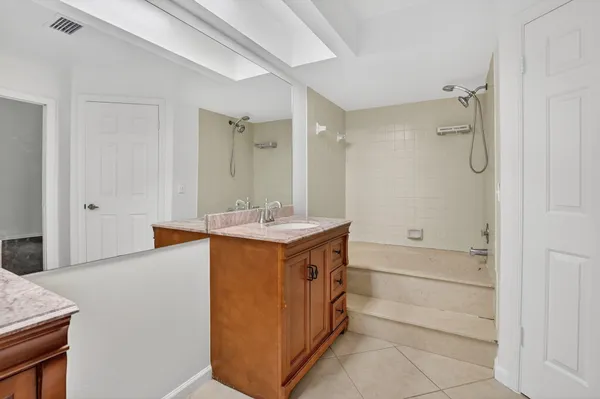 a bathroom with a double vanity sink mirror and shower