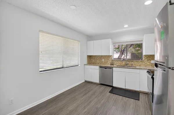 a kitchen with granite countertop white cabinets and white appliances