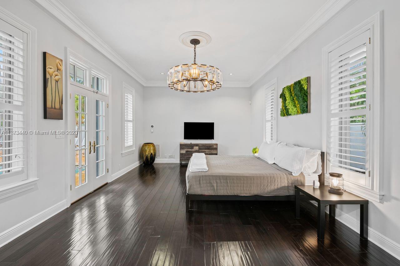 1401 South Ocean Drive Fort Lauderdale, FL 33316 - Photo 12 of 26 a bedroom with a bed and a chandelier