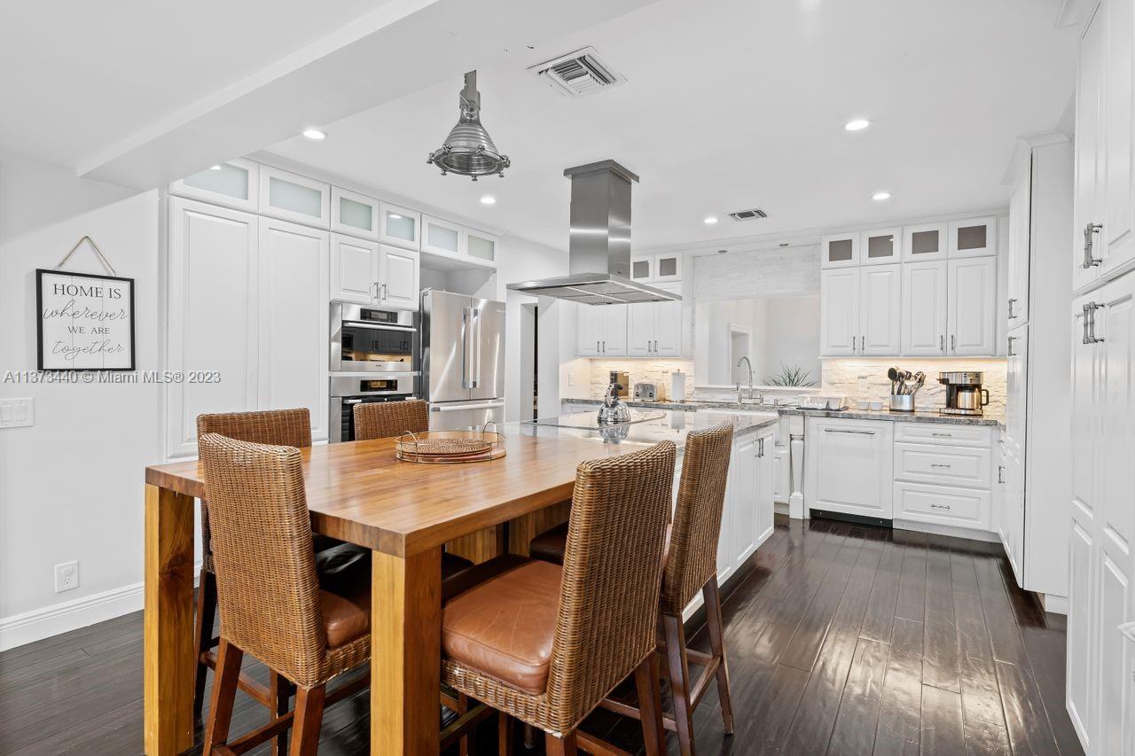 1401 South Ocean Drive Fort Lauderdale, FL 33316 - Photo 10 of 26 a kitchen with stainless steel appliances kitchen island granite countertop a table chairs and a refrigerator